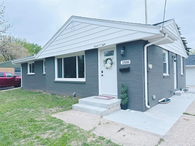 view of front of house with a garage, a front lawn, and brick siding