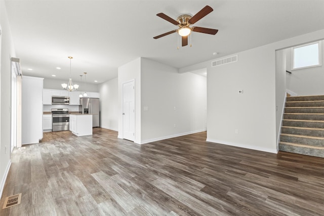 unfurnished living room with hardwood / wood-style flooring and ceiling fan with notable chandelier