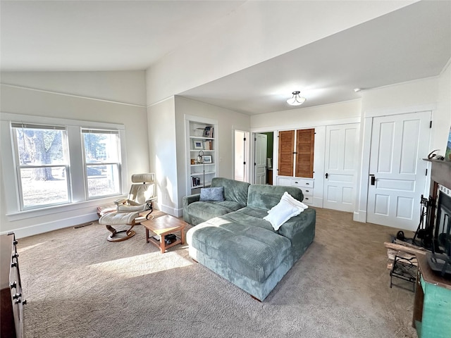 living room featuring lofted ceiling, built in features, and carpet