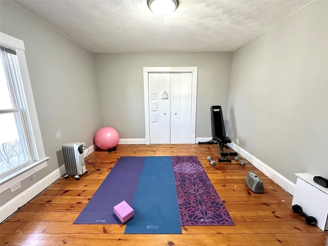 workout area featuring wood-type flooring and radiator