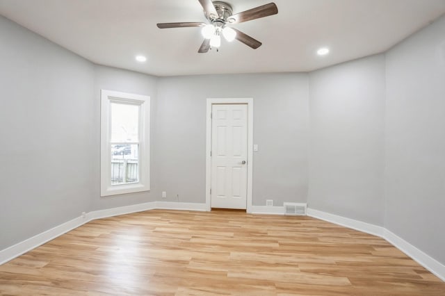 unfurnished room with a ceiling fan, light wood-style floors, visible vents, and baseboards