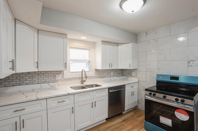 kitchen with tasteful backsplash, white cabinetry, stainless steel appliances, and a sink