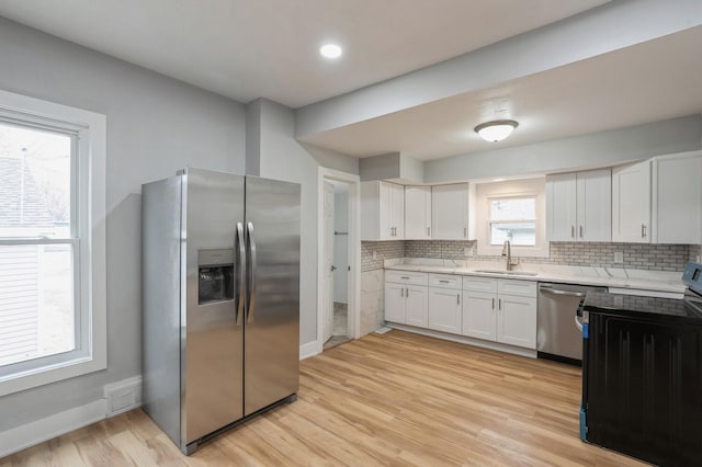 kitchen featuring tasteful backsplash, visible vents, stainless steel appliances, and a sink