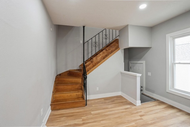 staircase with recessed lighting, baseboards, and wood finished floors