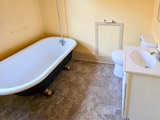 bathroom featuring a tub to relax in, toilet, and vanity