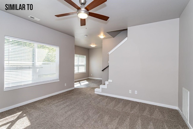 unfurnished living room with ceiling fan and carpet