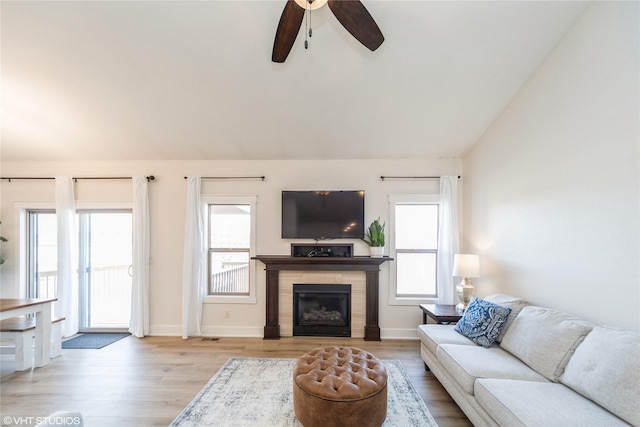 living room featuring ceiling fan, lofted ceiling, and light wood-type flooring