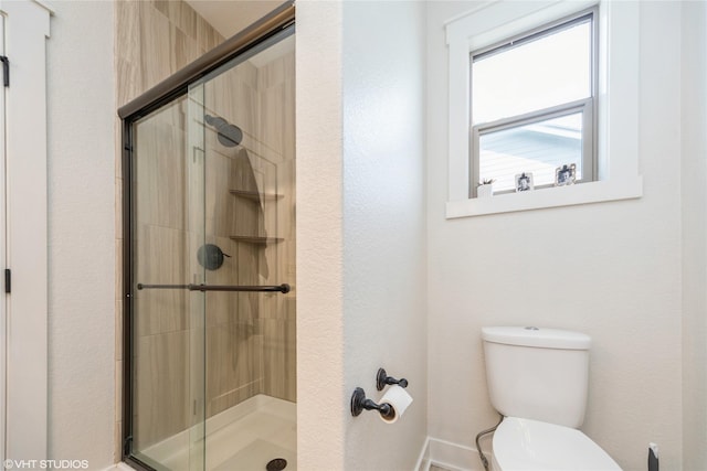 bathroom with an enclosed shower and toilet