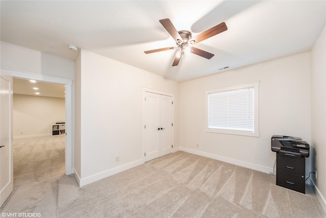 carpeted bedroom featuring ceiling fan and a closet