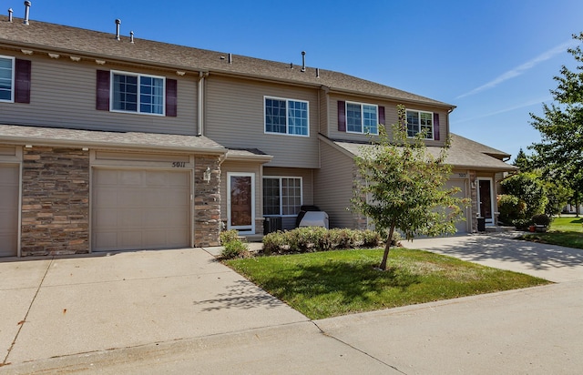 view of property featuring a garage and a front yard