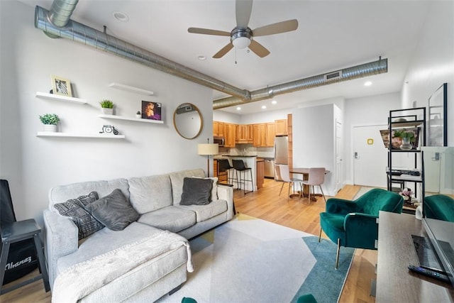 living room with ceiling fan and light wood-type flooring