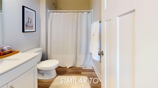 full bathroom featuring toilet, visible vents, wood finished floors, a shower with shower curtain, and vanity
