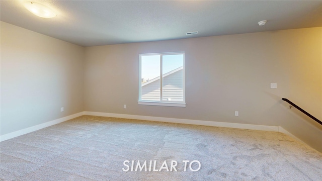 carpeted spare room with baseboards and visible vents