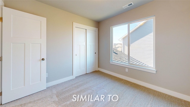 unfurnished bedroom featuring visible vents, a closet, baseboards, and carpet floors