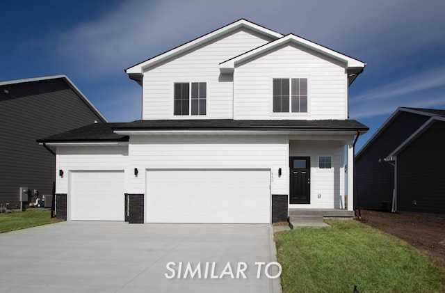 traditional home with an attached garage, concrete driveway, and a front lawn