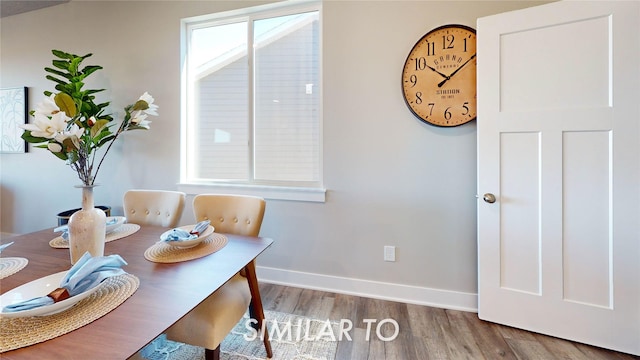 dining space with baseboards and wood finished floors