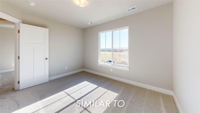 carpeted spare room with baseboards and visible vents