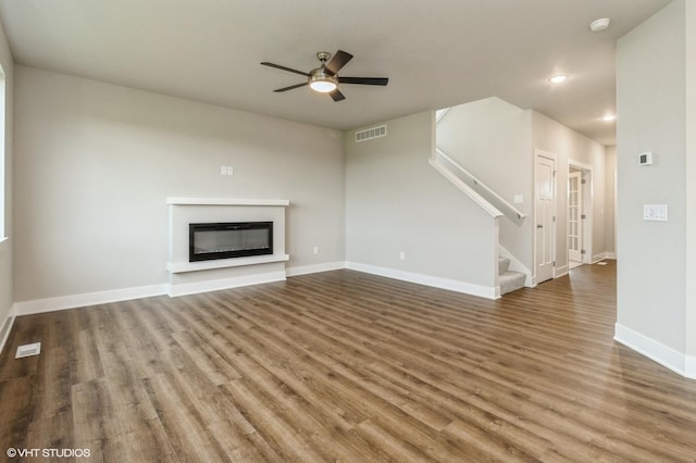 5656 Brook View Ave, Des Moines, IA 50317 - unfurnished living room featuring ceiling fan, a glass covered fireplace, wood finished floors, stairs, and recessed lighting