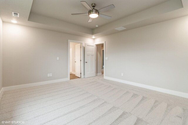 5656 Brook View Ave, Des Moines, IA 50317 - empty room featuring a raised ceiling, light carpet, and a ceiling fan