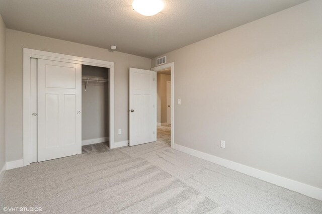 5656 Brook View Ave, Des Moines, IA 50317 - unfurnished bedroom featuring carpet floors, a textured ceiling, and a closet
