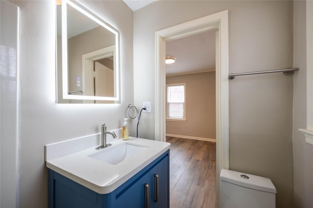 bathroom featuring vanity, hardwood / wood-style flooring, and toilet