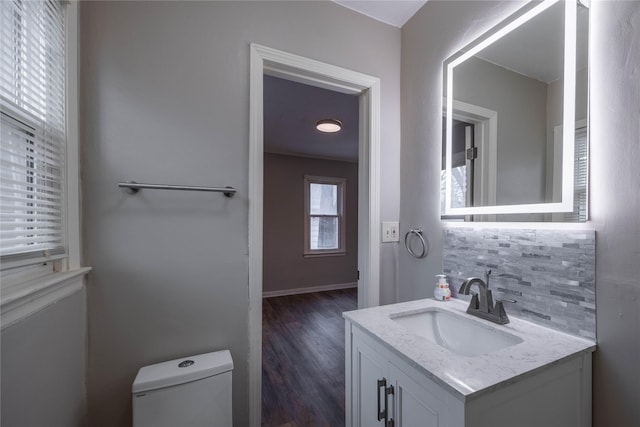 bathroom with vanity, toilet, wood-type flooring, and backsplash