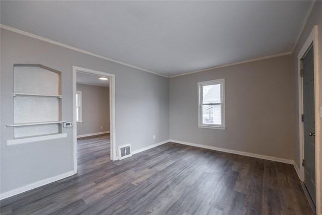 spare room featuring crown molding and dark wood-type flooring