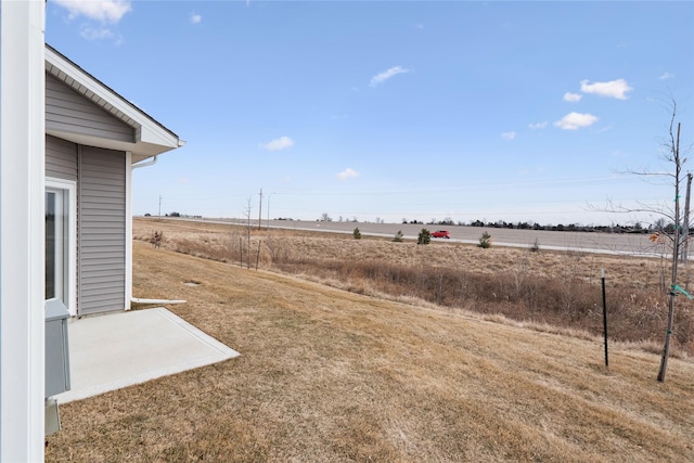 view of yard featuring a rural view and a patio