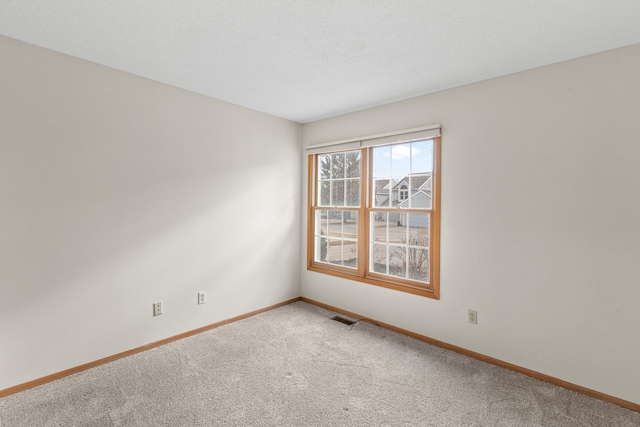 unfurnished room with carpet floors and a textured ceiling