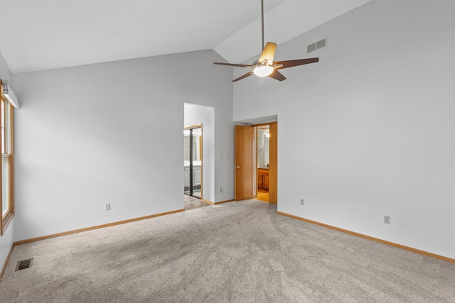 unfurnished bedroom with ceiling fan, connected bathroom, light colored carpet, and high vaulted ceiling