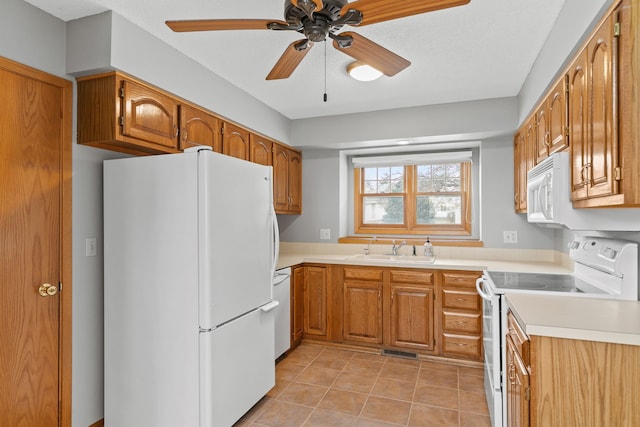 kitchen featuring sink, white appliances, ceiling fan, a textured ceiling, and light tile patterned flooring