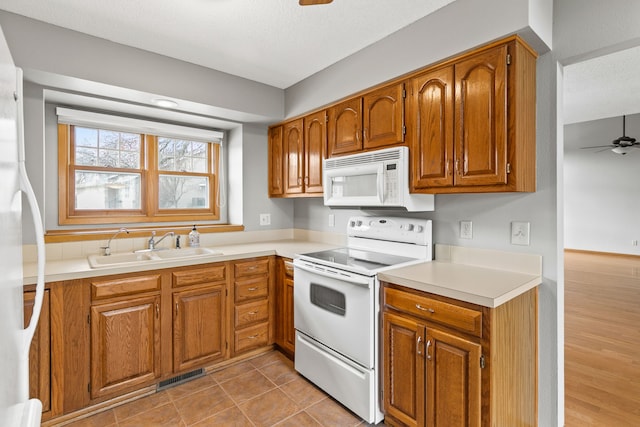 kitchen featuring ceiling fan, white appliances, and sink