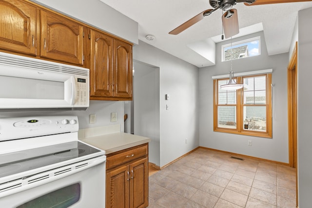 kitchen featuring white appliances, vaulted ceiling, decorative light fixtures, and ceiling fan