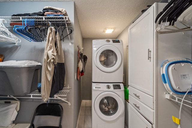 laundry room featuring tile patterned flooring, stacked washing maching and dryer, and a textured ceiling