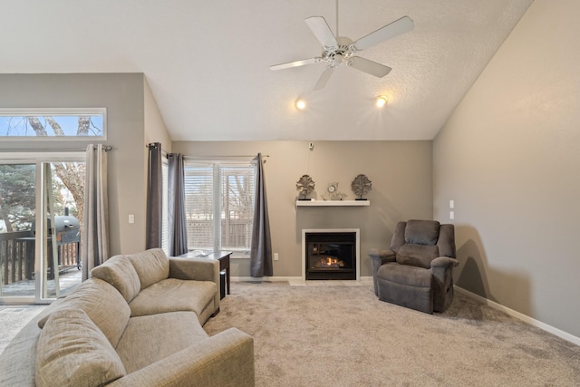 living room with ceiling fan, lofted ceiling, a healthy amount of sunlight, and light carpet