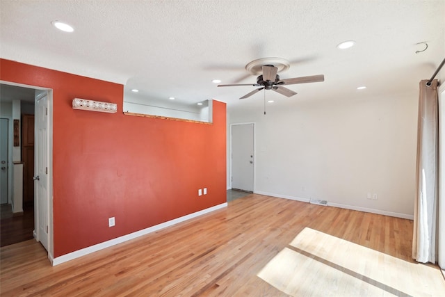 empty room featuring ceiling fan, light hardwood / wood-style flooring, and a textured ceiling