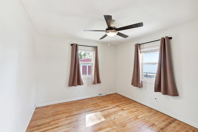 empty room with ceiling fan, light hardwood / wood-style flooring, and a healthy amount of sunlight