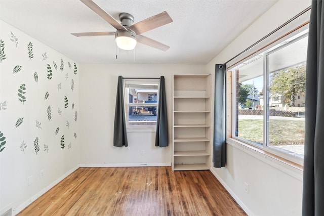 spare room with hardwood / wood-style flooring, ceiling fan, and a textured ceiling