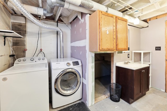 laundry area with cabinets, washing machine and dryer, and sink