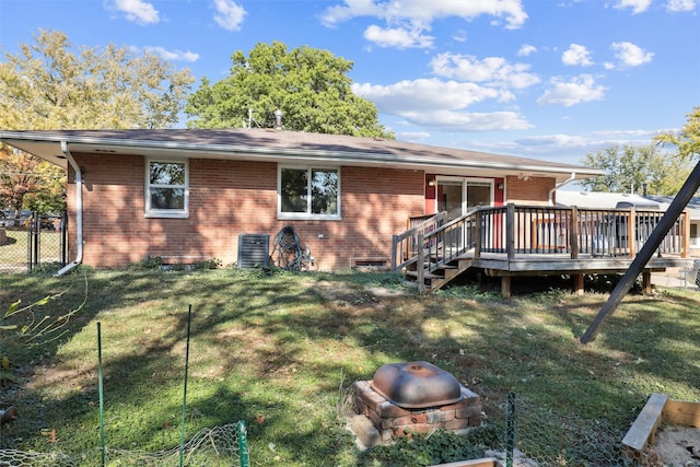 rear view of property with a yard and a deck