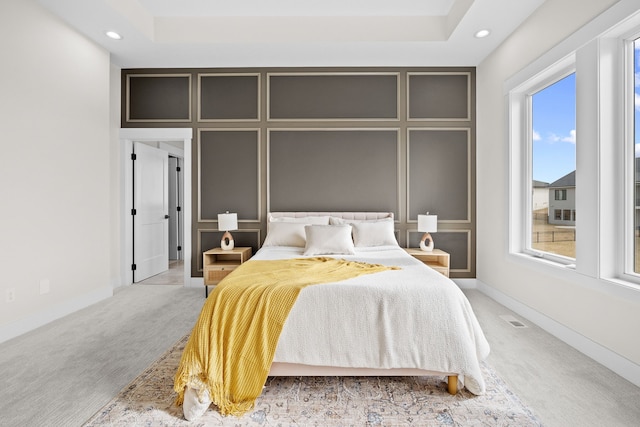 bedroom with recessed lighting, visible vents, a decorative wall, light carpet, and baseboards