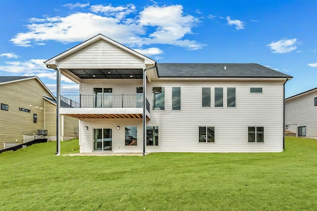 rear view of property featuring a yard, a patio, and a balcony