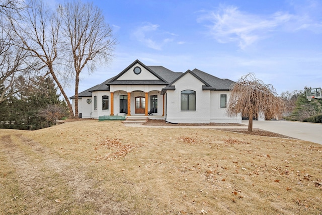 view of front of property with brick siding, roof with shingles, and concrete driveway