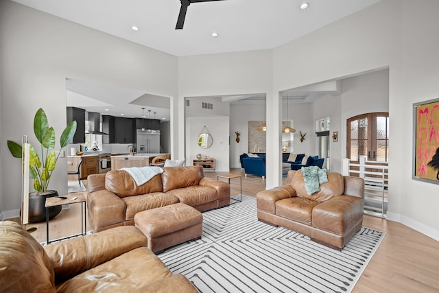 living room with light wood-type flooring, french doors, ceiling fan, and recessed lighting