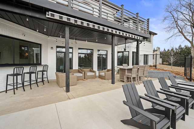 view of patio with outdoor dry bar, outdoor lounge area, and fence