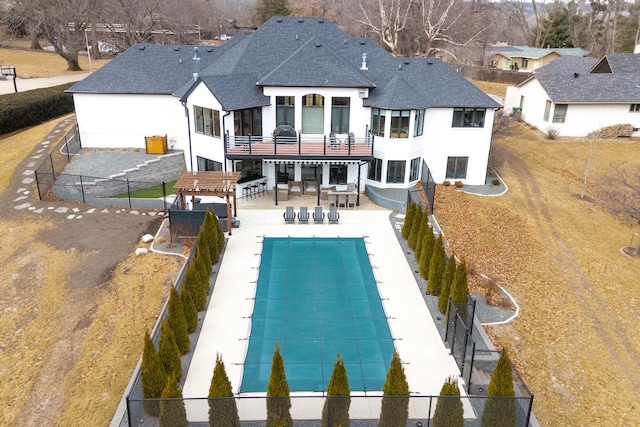 back of property with a patio, a balcony, a covered pool, and a pergola