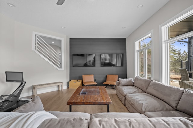 living area featuring an accent wall, recessed lighting, wood finished floors, and baseboards