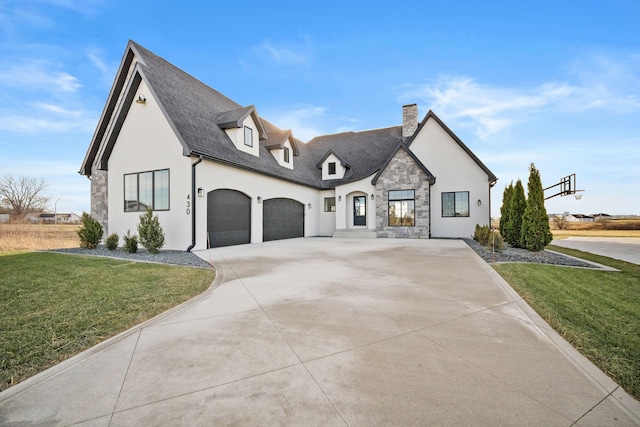 view of front of property with driveway, an attached garage, stucco siding, a front lawn, and stone siding