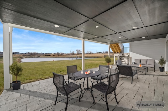 view of patio with stairway, outdoor lounge area, outdoor dining area, and a water view