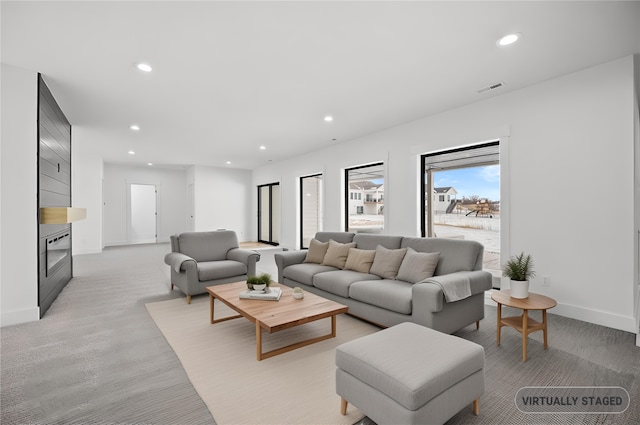 living area with recessed lighting, visible vents, and baseboards